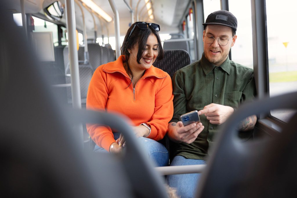 Nainen ja mies istuvat bussissa.